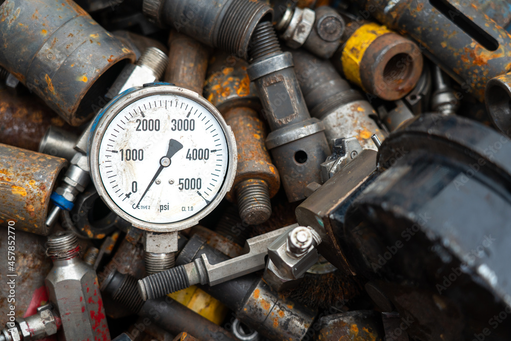 Broken pressure gauge or manometer which is junked on rusty metal scrap in junkyard. Industrial and electronic waste object photo. Broken pressure gauge or manometer which is junked on rusty metal scrap in junkyard. Industrial and electronic waste object photo.