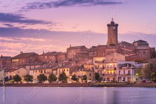 smooth water of lake Bolsena with view to city Marta in Italy