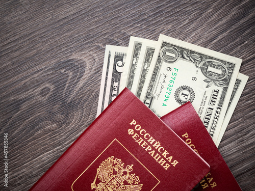 A foreign passport and dollars on a wooden background.