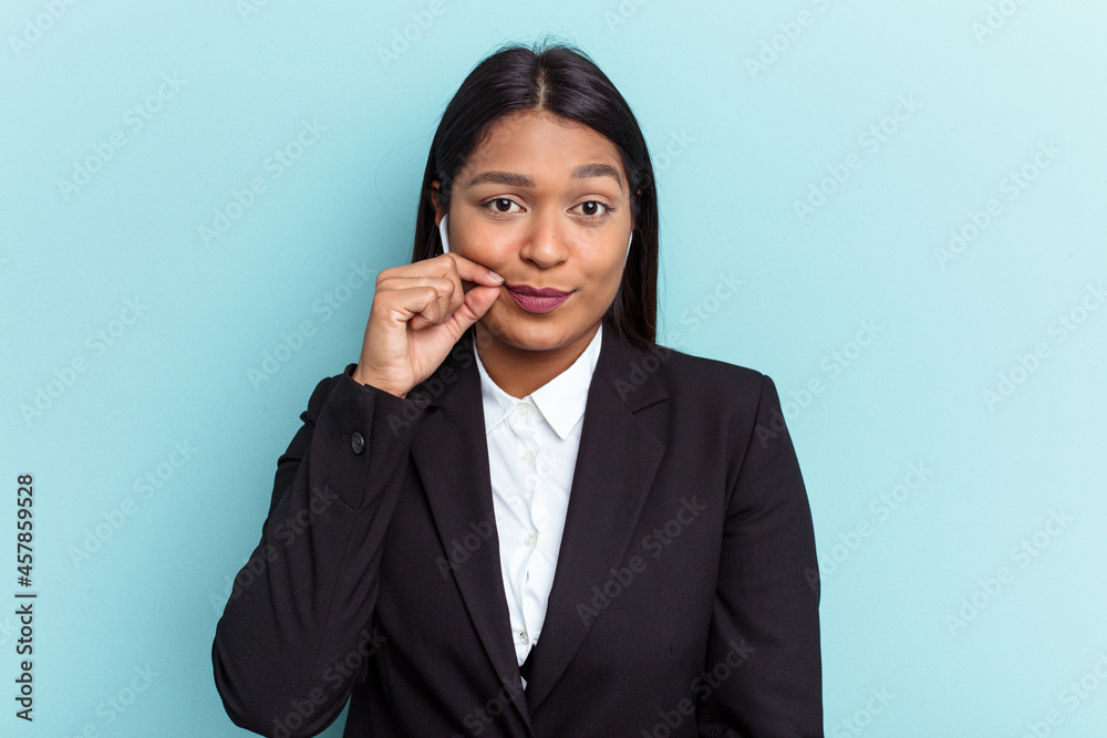 Young Venezuelan business woman isolated on blue background with fingers on lips keeping a secret. Young Venezuelan business woman isolated on blue background with fingers on lips keeping a secret.