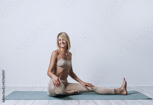 Obraz na płótnie a woman in full dawn of strength, a little over forty, performs exercises from yoga. a woman has healthy well-groomed skin and hair, a toned figure and healthy shine in her eyes w salonie