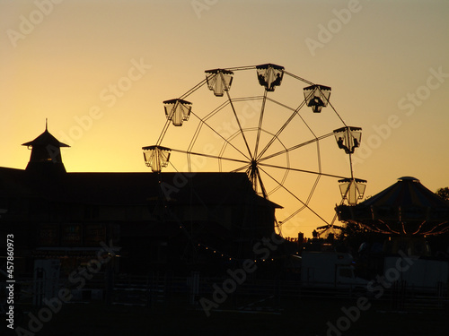 Silhouette of ferris wheel and buildings at a showground photo