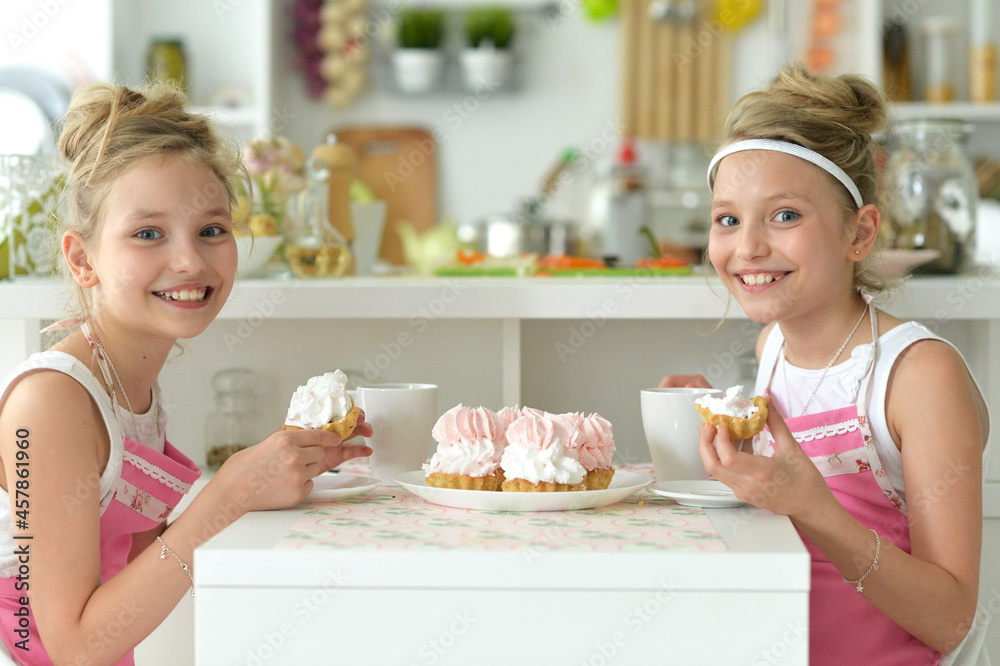 Portrait of cute girls eating cakes in the kitchen at home Portrait of cute girls eating cakes in the kitchen at home