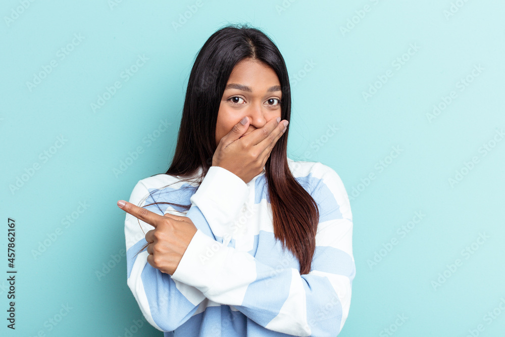 Young Venezuelan woman isolated on blue background pointing to the side Young Venezuelan woman isolated on blue background pointing to the side