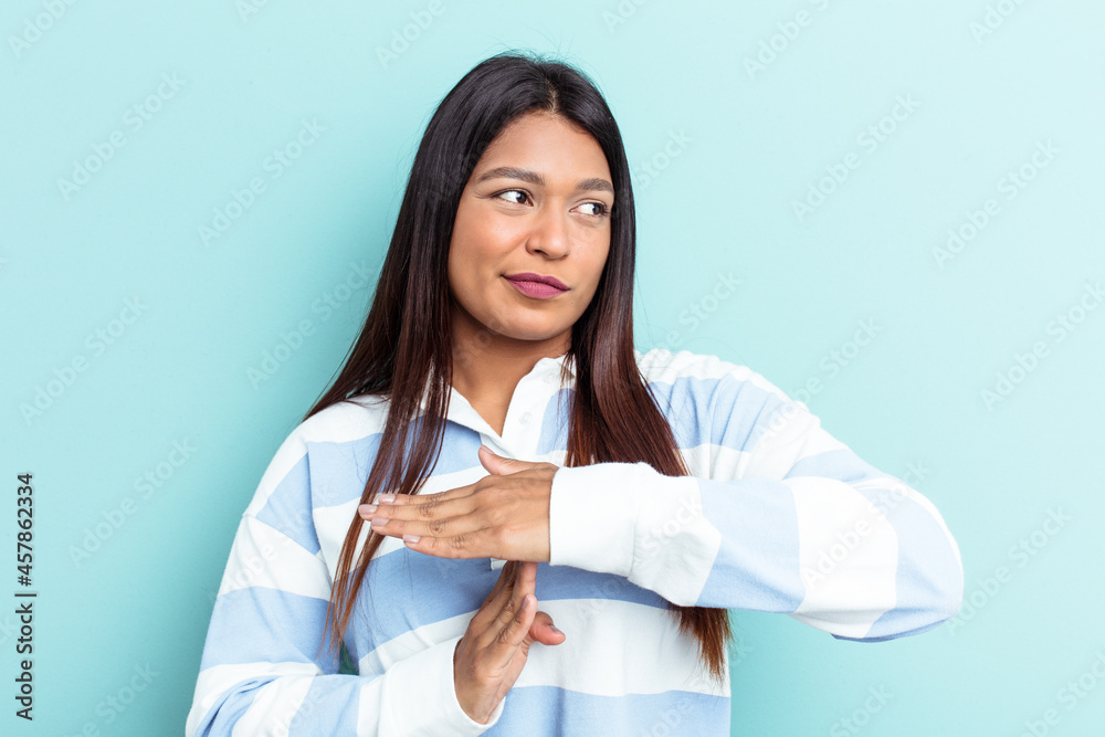 Young Venezuelan woman isolated on blue background showing a timeout gesture. Young Venezuelan woman isolated on blue background showing a timeout gesture.