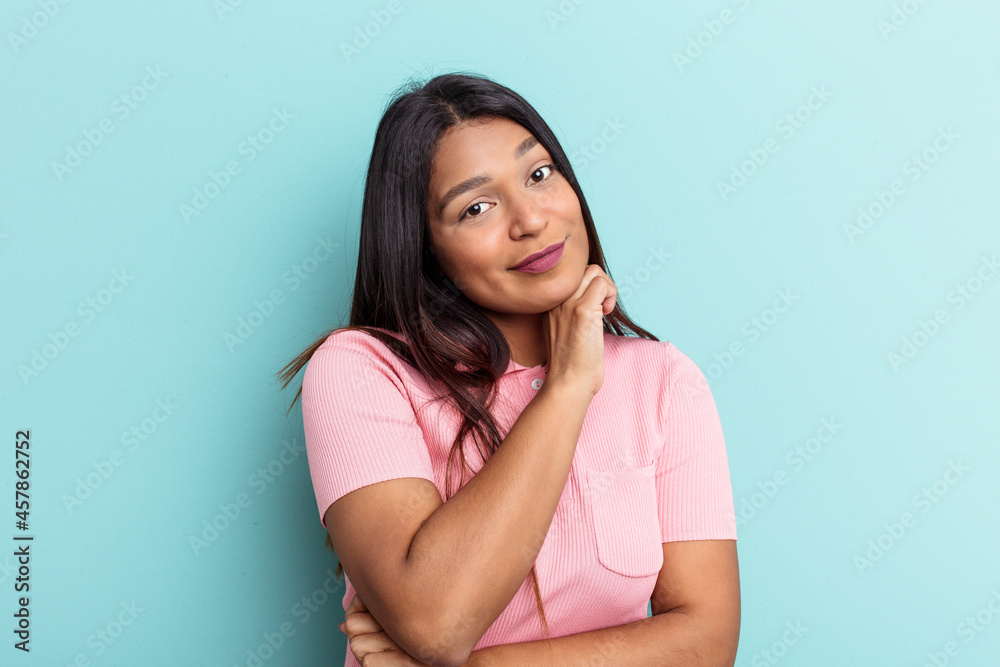 Young Venezuelan woman isolated on blue background tired of a repetitive task. Young Venezuelan woman isolated on blue background tired of a repetitive task.