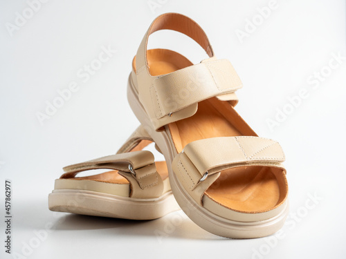 close-up of beige leather sandals on a white background. Pair of shoes, Women's flight shoes