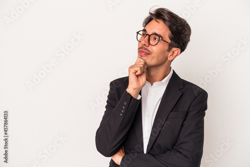Young mixed race business man isolated on white background looking sideways with doubtful and skeptical expression.