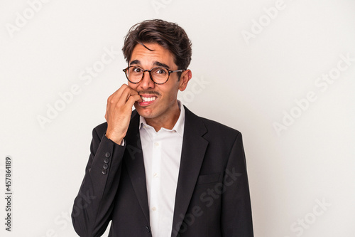 Young mixed race business man isolated on white background biting fingernails, nervous and very anxious.