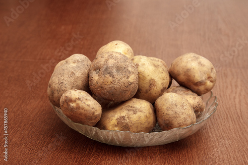 plate with raw potatoes on the table