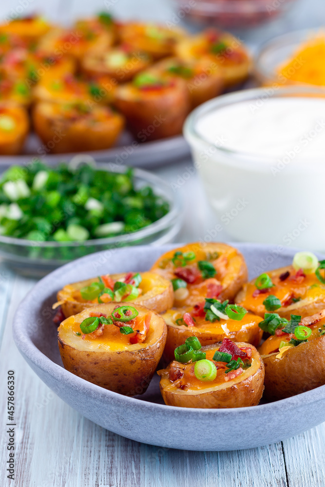 Mini red skinned loaded potatoes with crispy bacon, scallions and sharp cheddar cheese, closeup Mini red skinned loaded potatoes with crispy bacon, scallions and sharp cheddar cheese, closeup