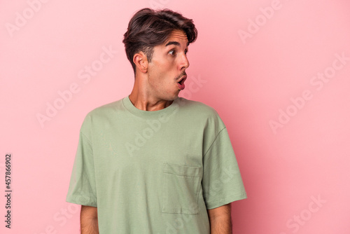 Young mixed race man isolated on white background being shocked because of something she has seen. photo