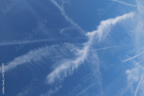 Full frame blue sky with various white vapour trails spreading and disolving photo