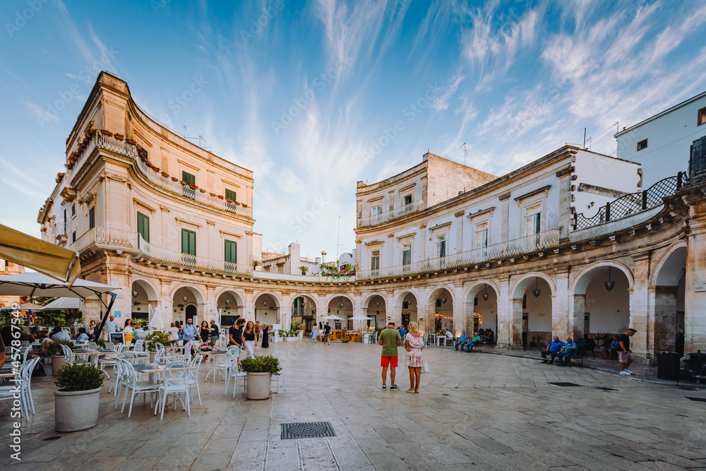 Largo Piazza Maria Immacolata in the historic center of Martina Franca at sunset with people walking around