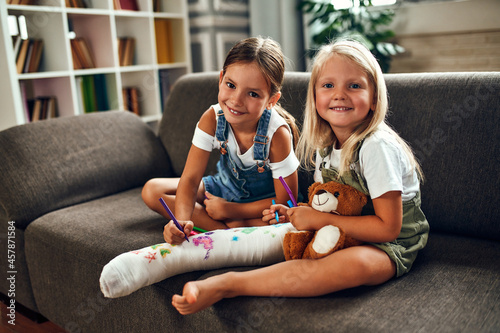 Obraz na plátně Little girl with a broken leg on the couch