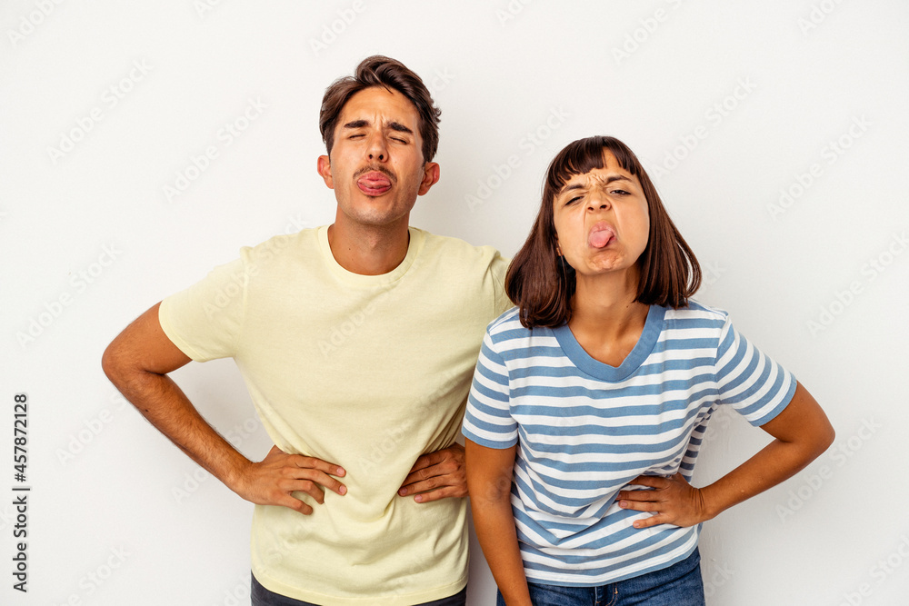 Young mixed race couple isolated on white background funny and friendly sticking out tongue. Young mixed race couple isolated on white background funny and friendly sticking out tongue.