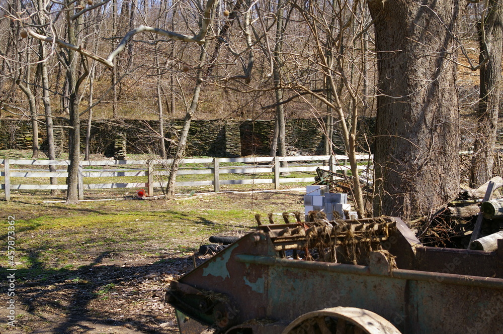 antique farm equipment with fence and trees