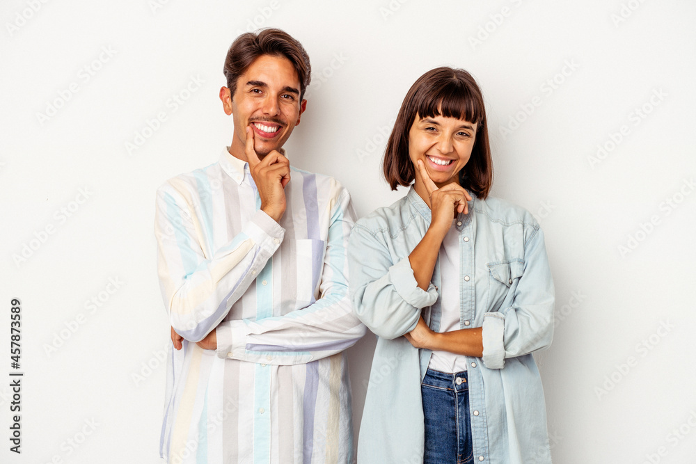 Young mixed race couple isolated on white background smiling happy and confident, touching chin with hand. Young mixed race couple isolated on white background smiling happy and confident, touching chin with hand.