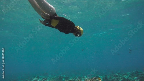 Pretty Free diver exploring coral reef of a red sea. Freediving is a sport when a person dives into sea water while holding his breath. An extreme type of underwater diving to a depth without photo