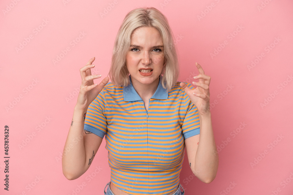 Young caucasian woman isolated on pink background upset screaming with tense hands. Young caucasian woman isolated on pink background upset screaming with tense hands.