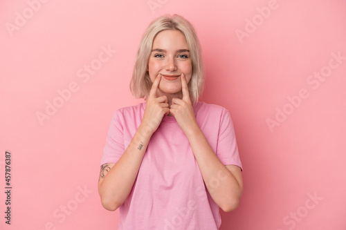 Young caucasian woman isolated on pink background doubting between two options.