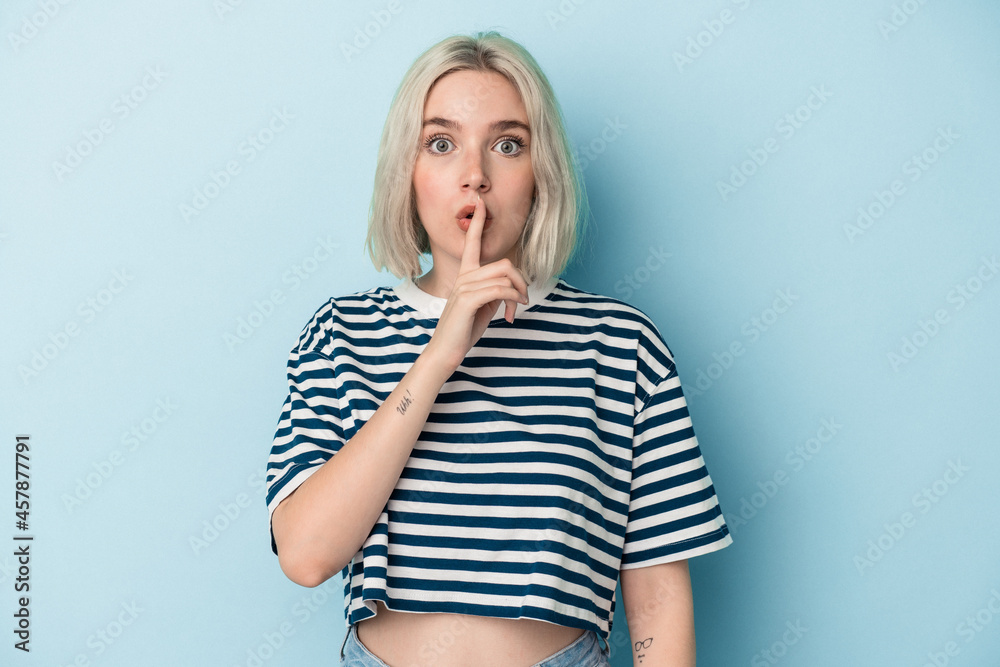 Young caucasian woman isolated on blue background keeping a secret or asking for silence. Young caucasian woman isolated on blue background keeping a secret or asking for silence.