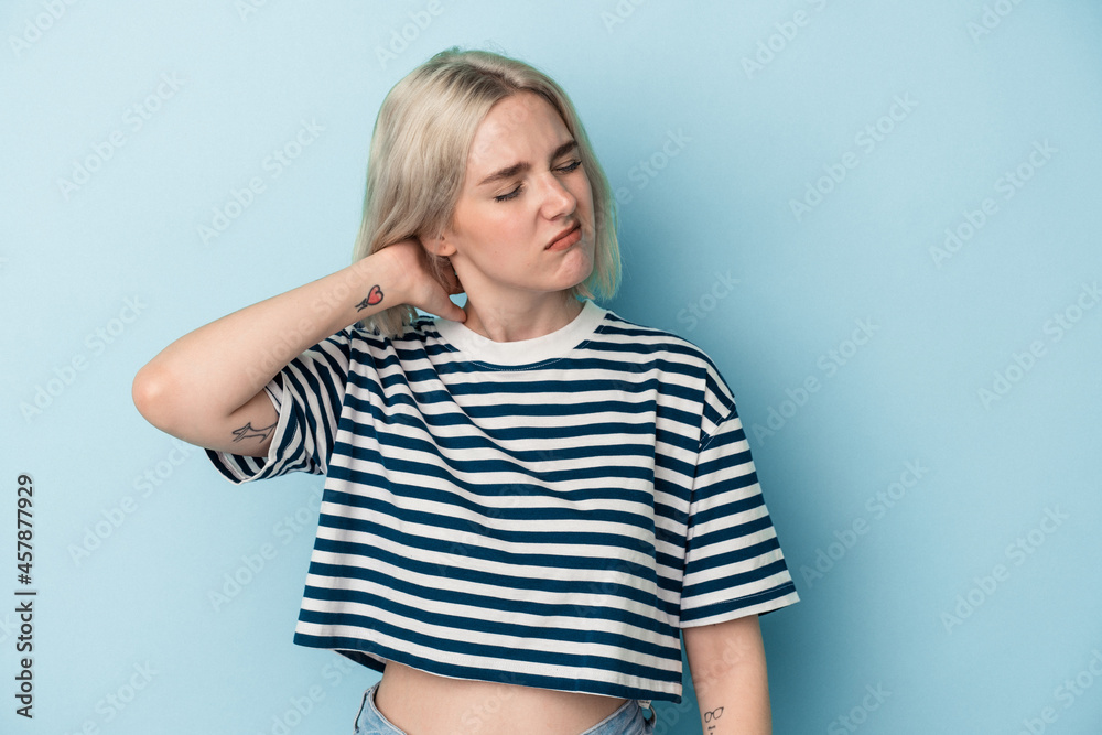 Young caucasian woman isolated on blue background having a neck pain due to stress, massaging and touching it with hand. Young caucasian woman isolated on blue background having a neck pain due to stress, massaging and touching it with hand.