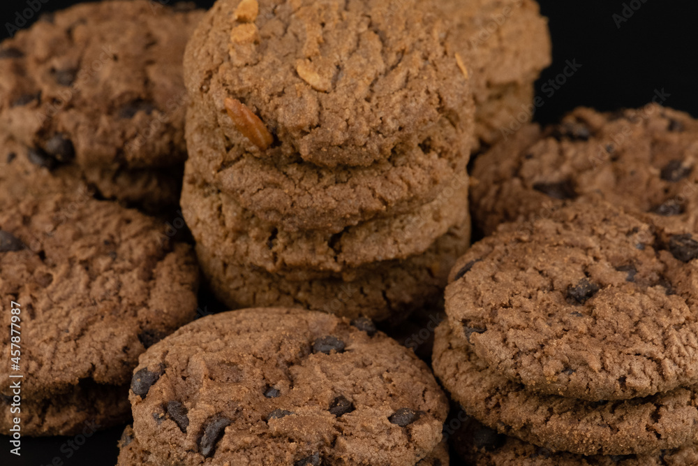 Delicious tasty snack of brown cookies with chocolate chip and peanut isolated on black background