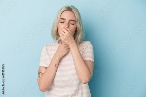 Young caucasian woman isolated on blue background suffers pain in throat due a virus or infection.