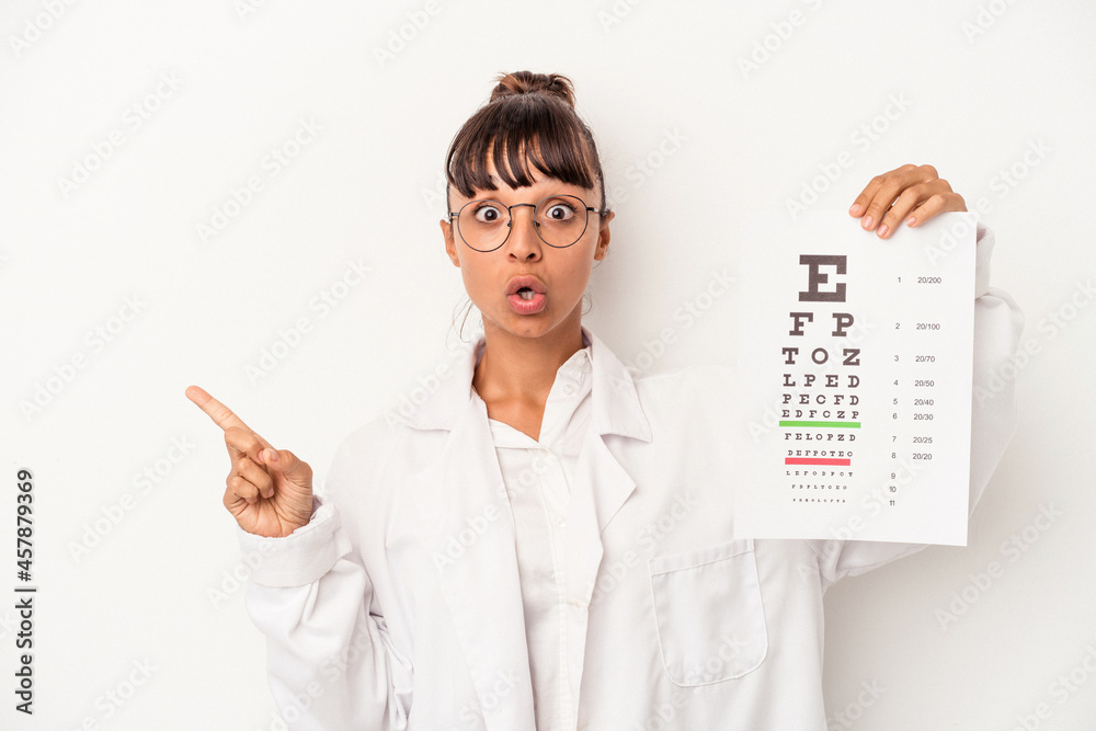 Young mixed race optician woman doing a test isolated on white background pointing to the side Young mixed race optician woman doing a test isolated on white background pointing to the side