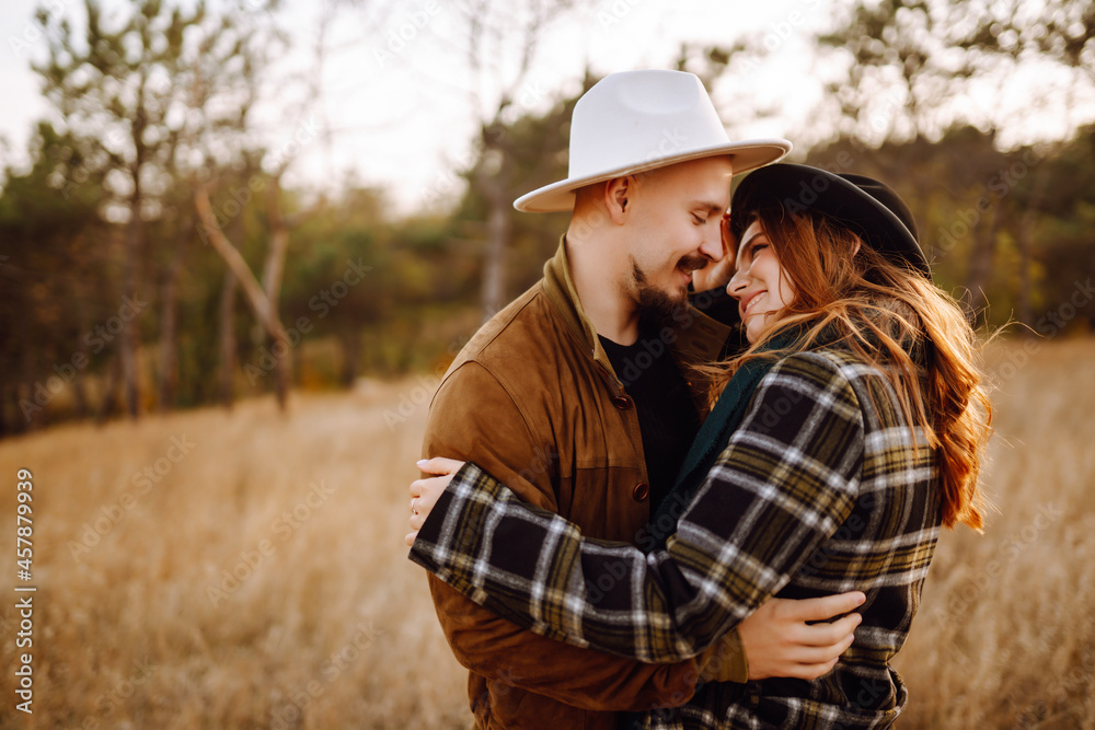Romantic couple in love walking in the autumn park. Love story. Autumn style. Kiss and hugs. Romantic couple in love walking in the autumn park. Love story. Autumn style. Kiss and hugs.