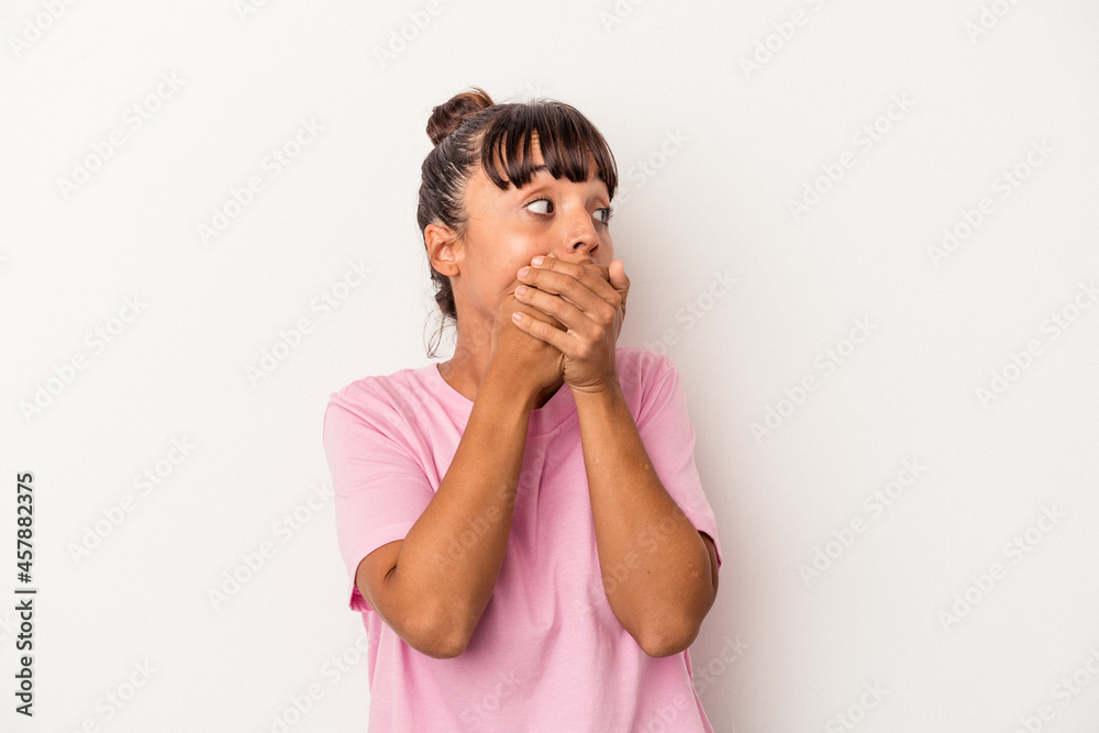 Young mixed race woman isolated on white background thoughtful looking to a copy space covering mouth with hand. Young mixed race woman isolated on white background thoughtful looking to a copy space covering mouth with hand.