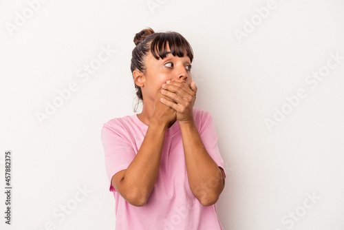 Young mixed race woman isolated on white background thoughtful looking to a copy space covering mouth with hand.