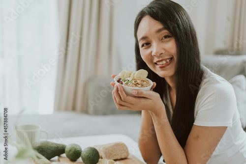Fit woman smilling with healthy food. Young woman cooking healthy food at home. Healthy and wellness concept.