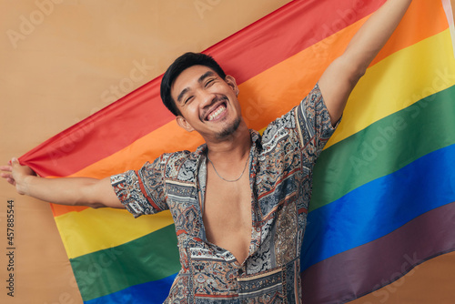 Happy man smiling and standing with pride flag. Gender Equality and LGBTQ concept.