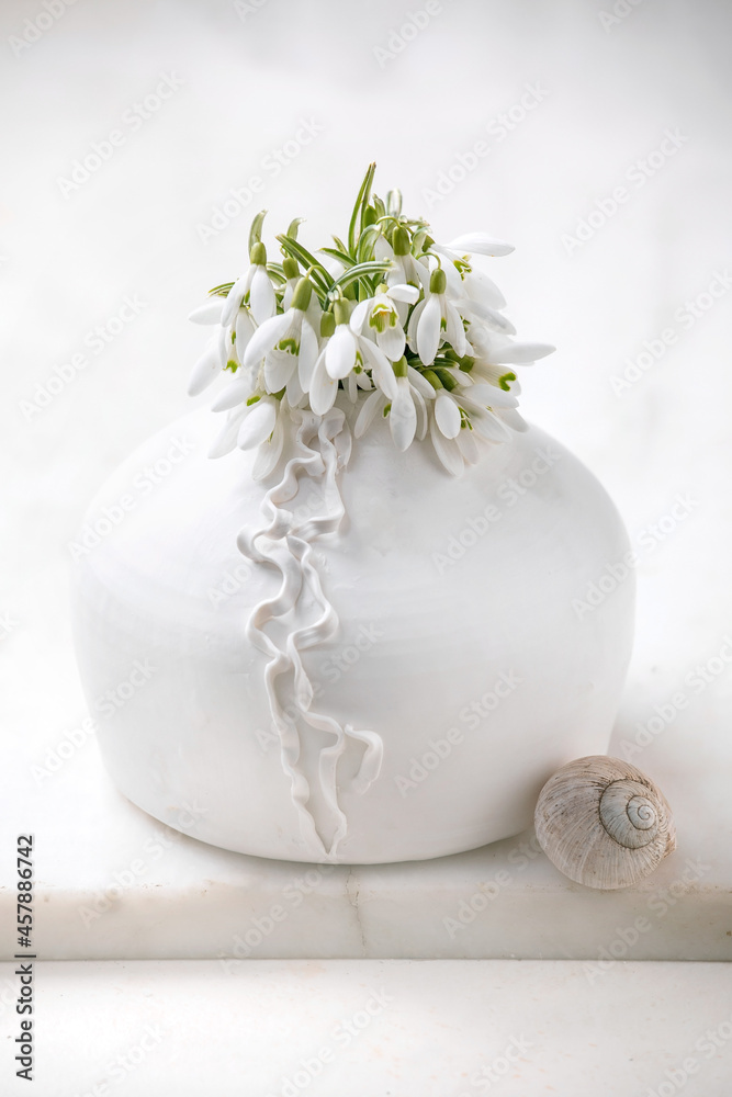 Bouquet of snowdrops flowers in white vase