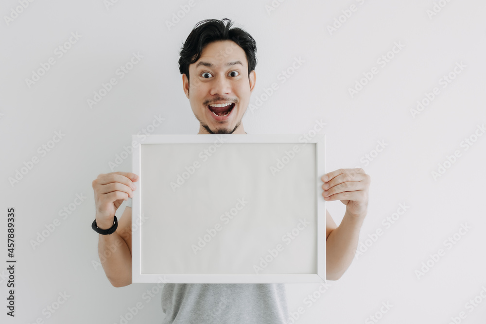 Happy Asian man holding an empty photo frame isolated on white background. Happy Asian man holding an empty photo frame isolated on white background.