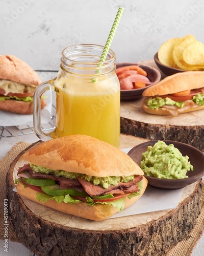 Sánduche de roast beef con salsa de guacamole, papas fritas y jugo de naranja photo