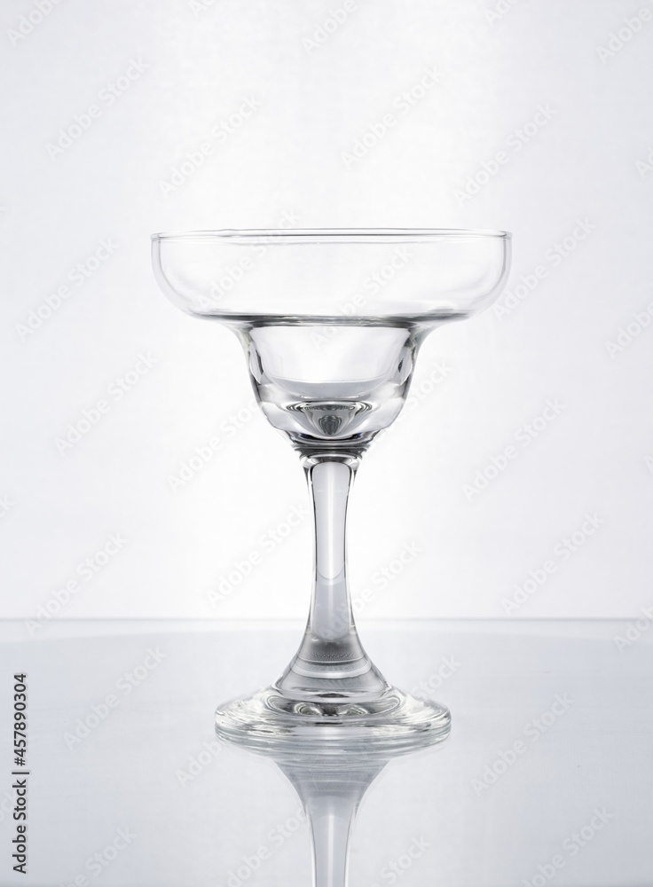 Copa de cristal con forma para margatitas en fondo blanco gris Copa de cristal con forma para margatitas en fondo blanco gris
