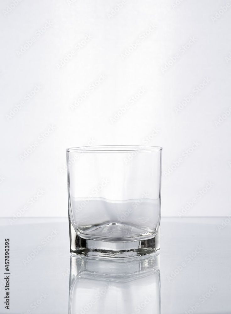Vaso de cristal con forma para whisky en fondo blanco gris Vaso de cristal con forma para whisky en fondo blanco gris