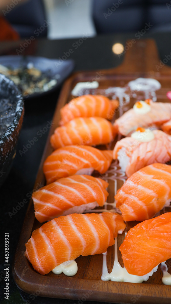 Salmon Sushi Japanese food. on the table in restaurant. Japanese cuisine set of Sashimi Salmon sushi nigiri. Salmon Sushi Japanese food. on the table in restaurant. Japanese cuisine set of Sashimi Salmon sushi nigiri.