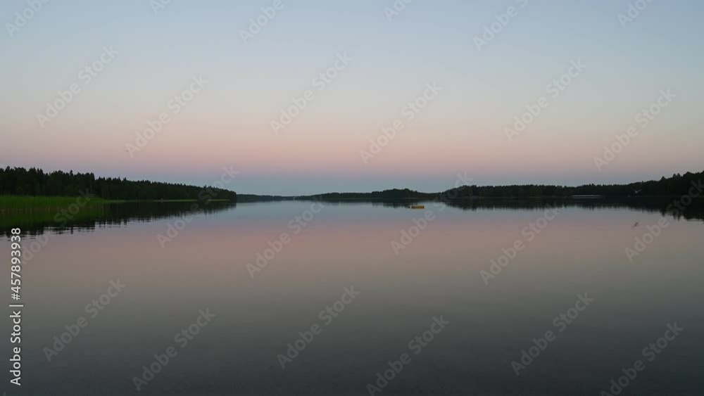 4K tranquil view of the closeup dandelion beside the lake during sunset through the horizon. Cloud reflection on the water 4K video. 4K tranquil view of the closeup dandelion beside the lake during sunset through the horizon. Cloud reflection on the water 4K video.