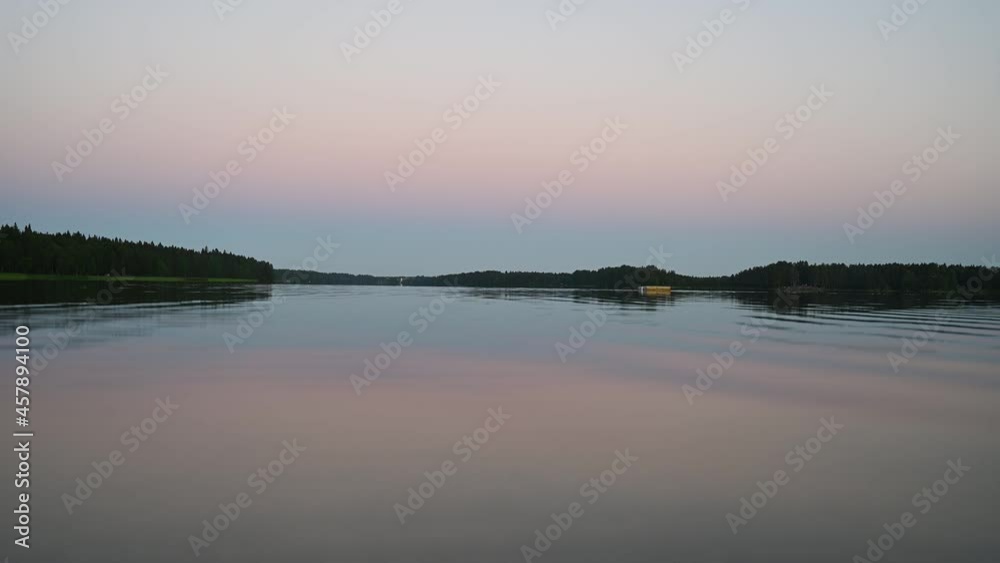4K tranquil view of the closeup dandelion beside the lake during sunset through the horizon. Cloud reflection on the water 4K video. 4K tranquil view of the closeup dandelion beside the lake during sunset through the horizon. Cloud reflection on the water 4K video.