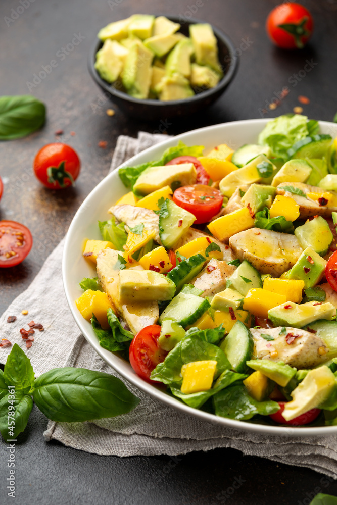 Tasty Chicken mango salad with avocado, cucumber, cherry tomatoes. Healthy food