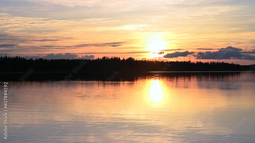 4K tranquil view of the closeup dandelion beside the lake during sunset through the horizon. Cloud reflection on the water 4K video. 4K tranquil view of the closeup dandelion beside the lake during sunset through the horizon. Cloud reflection on the water 4K video.
