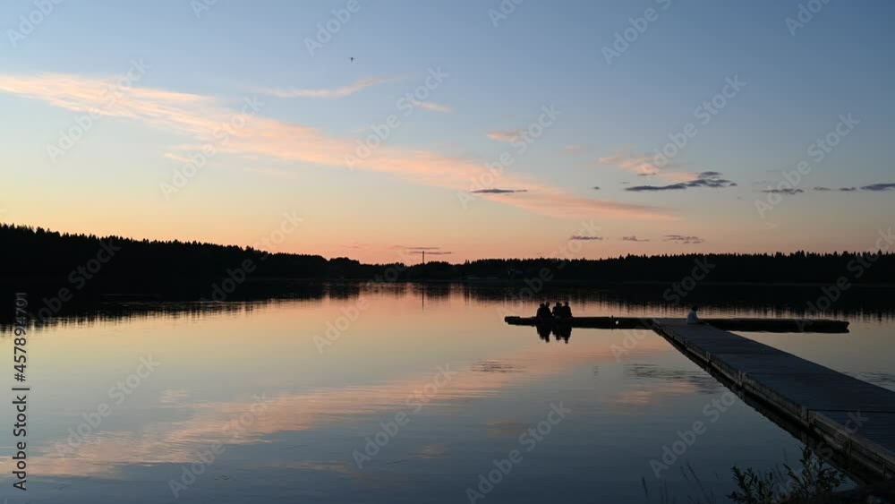 4K tranquil view of the closeup dandelion beside the lake during sunset through the horizon. Cloud reflection on the water 4K video. 4K tranquil view of the closeup dandelion beside the lake during sunset through the horizon. Cloud reflection on the water 4K video.