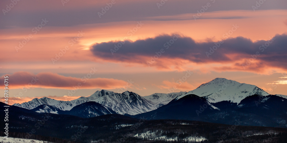 Sunset behind a snow covered mountain