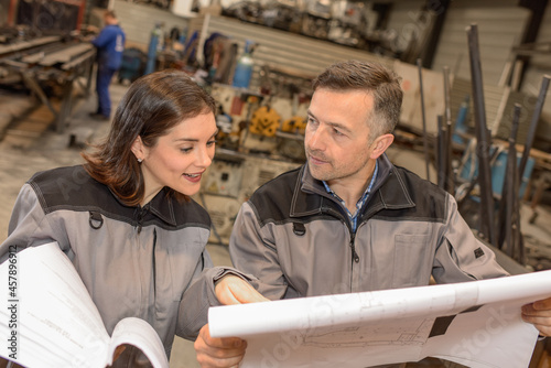 Concentrated workers  analysing dimensioned industrial drawing photo