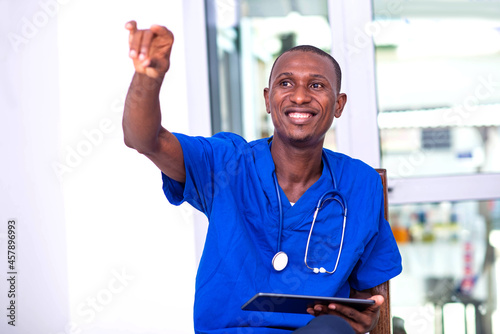 young male doctor holding digital tablet and gesturing hand.
