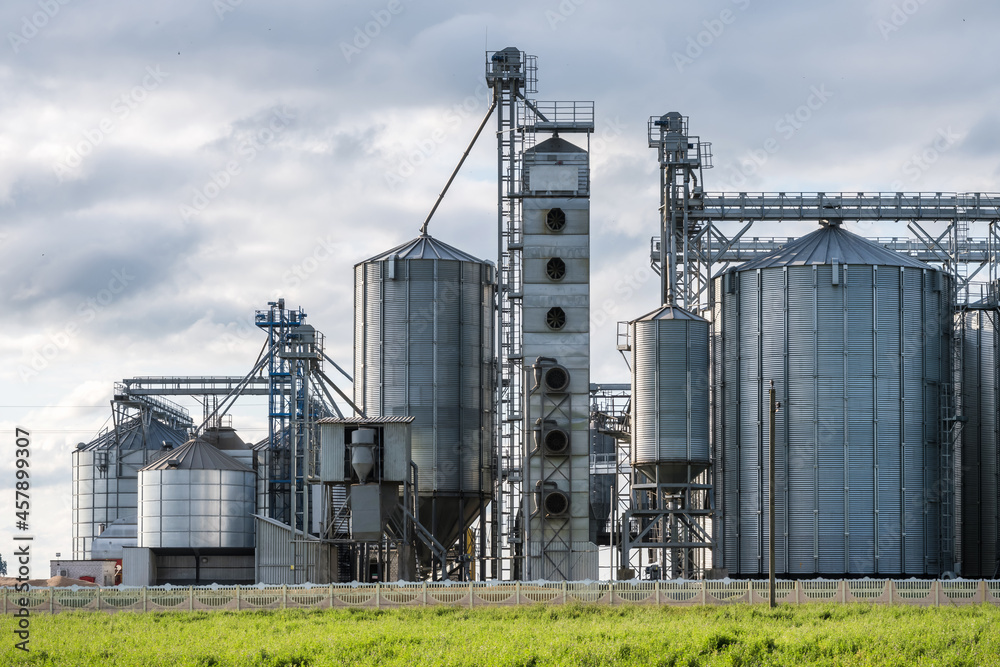 Modern Granary elevator and seed cleaning line. Silver silos on agro-processing and manufacturing plant for storage and processing drying cleaning of agricultural products, flour, cereals and grain. Modern Granary elevator and seed cleaning line. Silver silos on agro-processing and manufacturing plant for storage and processing drying cleaning of agricultural products, flour, cereals and grain.